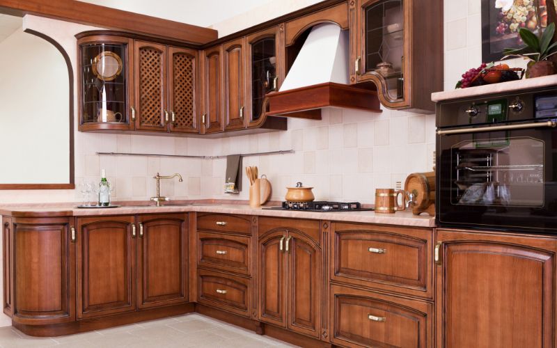 A compact modular kitchen with wooden finishes and built-in storage solutions.