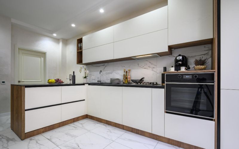 A contemporary kitchen with sleek white cabinets and elegant marble countertops.