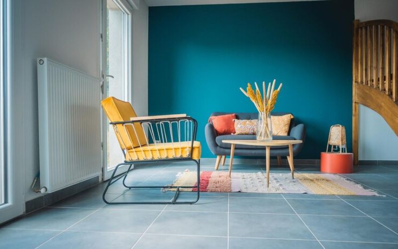 Blue walls and yellow chairs in a cozy living room, showcasing a vibrant home painting.